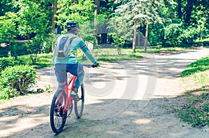 Cyclist in helmet on orange bike riding in park