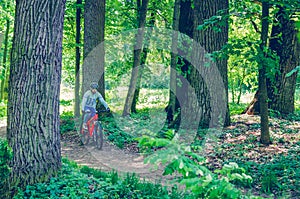 Cyclist in helmet on orange bike riding in park