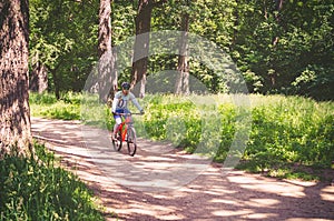 Cyclist in helmet on orange bike riding in park