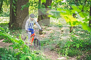 Cyclist in helmet on orange bike riding in park