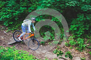 A cyclist in a helmet is riding off-road, motion blur