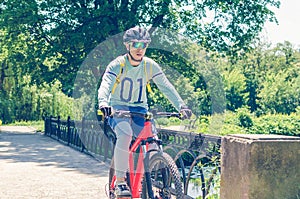 Cyclist in helmet riding in park on bridge