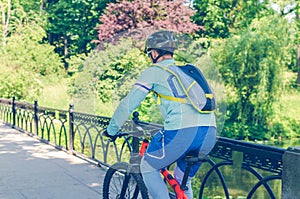 Cyclist in helmet riding in park on bridge