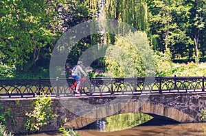 Cyclist in helmet riding in park on bridge