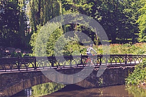 Cyclist in helmet riding in park on bridge