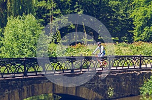 Cyclist in helmet riding in park on bridge