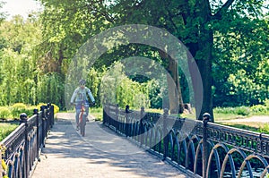 Cyclist in helmet riding in park on bridge