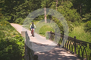 Cyclist in helmet riding in park on bridge