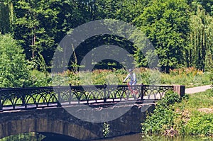 Cyclist in helmet riding in park on bridge