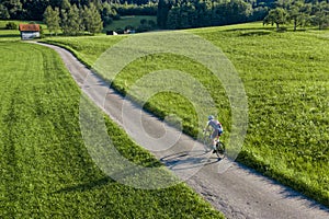 Cyclist with long shadow in a view from above