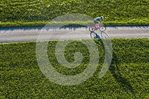 Cyclist with long shadow in a view from above