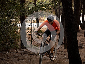 Cyclist man in a forest pedaling a mountain bike