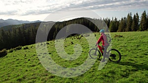 Cyclist man riding electric bike outdoors, enjoying beautiful mountain landscape.