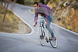 Cyclist man riding fixed gear sport bike in sunny day