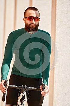 Cyclist man riding fixed gear sport bike in sunny day on a city