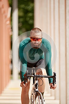 Cyclist man riding fixed gear sport bike in sunny day on a city