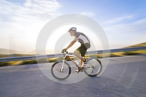 Cyclist man riding mountain bike in sunny day