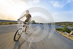 Cyclist man riding mountain bike in sunny day