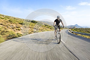 Cyclist man riding mountain bike in sunny day