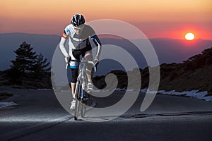 Cyclist man riding mountain bike at sunset