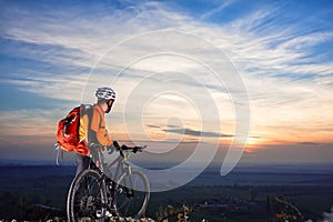 cyclist on mountain-bike background of beautiful sunset.