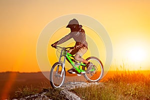 Cyclist with mountain bike on the hill in the evening