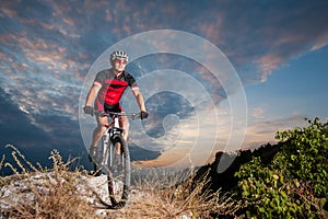 Cyclist on mountain bike races downhill in the nature