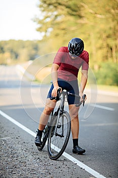 Cyclist with muscular legs preparing for morning ride