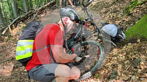 Cyclist pumping bicycle wheel outdoors.