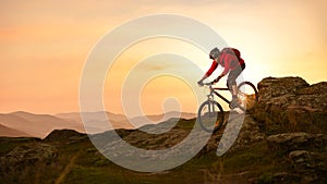 Cyclist in Red Riding Bike on the Summer Rocky Trail at Sunset. Extreme Sport and Enduro Biking Concept