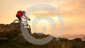 Cyclist in Red Riding Bike on the Summer Rocky Trail at Sunset. Extreme Sport and Enduro Biking Concept