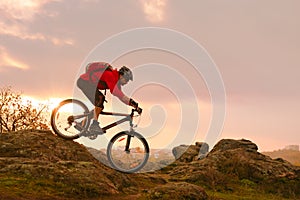 Cyclist in Red Riding Bike on the Summer Rocky Trail at Sunset. Extreme Sport and Enduro Biking Concept