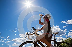 Cyclist resting and drinking isotonic drink.