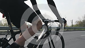 Cyclist riding a bicycle and changing gears. Close up follow shot. Cyclist pedaling on bicycle in motion.