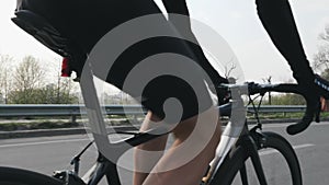 Cyclist riding a bicycle and changing gears. Close up follow shot. Cyclist pedaling on bicycle in motion. Slow motion