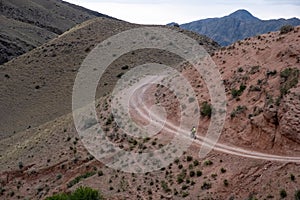 Cyclist is riding bicycle on gravel road in the mountains. Woman cycling MTB on gravel road trail track. Outdoor sport activity photo