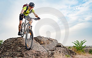 Cyclist Riding the Bike on Autumn Rocky Trail at Sunset. Extreme Sport and Enduro Biking Concept.