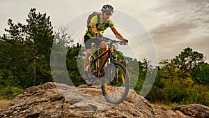 Cyclist Riding the Bike on Autumn Rocky Trail at Sunset. Extreme Sport and Enduro Biking Concept.