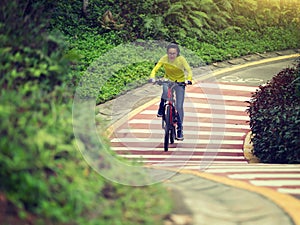 Cyclist riding bike on forest trail