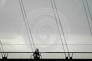A cyclist riding on a cable stayed bridge