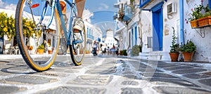 Cyclist riding through historic alleyways with stone houses and windmills in old town photo