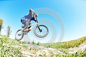 Cyclist riding jumping with bicycle cross-country