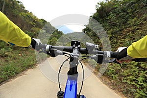 Cyclist riding mountain bike on road