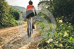 Cyclist riding mountain bike on rocky trail