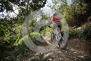 Cyclist riding mountain bike on rocky trail