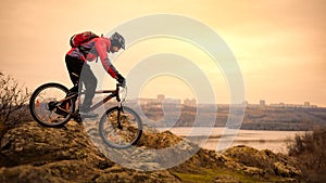 Cyclist Riding the Mountain Bike on the Rocky Trail at Autumn Evening. Extreme Sport and Enduro Cycling Concept.