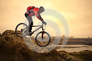 Cyclist Riding the Mountain Bike on the Rocky Trail at Cold Autumn Evening. Extreme Sport and Enduro Cycling Concept.