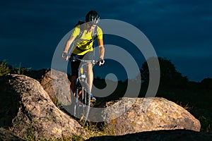 Cyclist Riding the Mountain Bike on Rocky Trail in the Evening. Extreme Sport and Enduro Biking Concept.