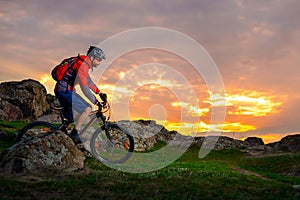 Cyclist Riding Mountain Bike on the Spring Rocky Trail at Beautiful Sunset. Extreme Sports and Adventure Concept.