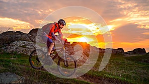 Cyclist Riding Mountain Bike on the Spring Rocky Trail at Beautiful Sunset. Extreme Sports and Adventure Concept.